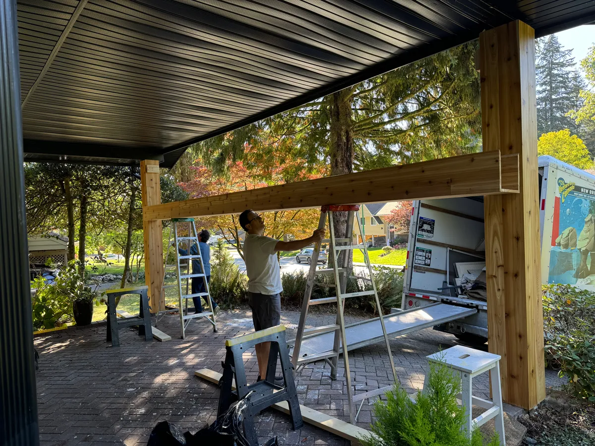 Crew positioning header beam across wrapped porch columns